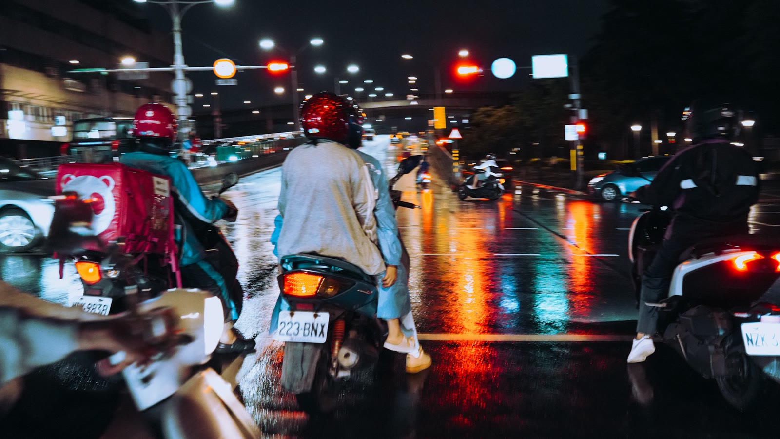 Gece trafiğinde iki tekerliler ve fren lambaları